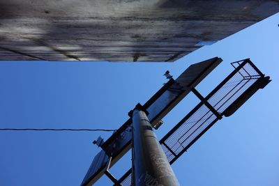 Low angle view of windmill against blue sky
