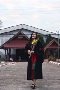 Portrait of young woman standing in city