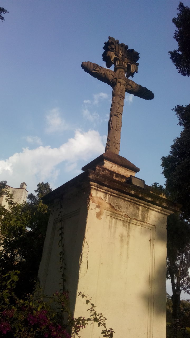 religion, spirituality, place of worship, low angle view, tree, built structure, architecture, cross, history, sky, human representation, statue, famous place, art and craft, temple - building, art, sculpture, church