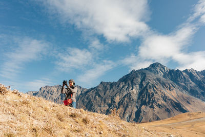 People standing on mountain against sky