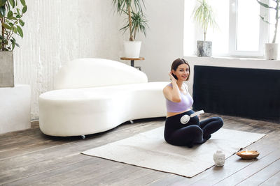 Portrait of pregnant woman sitting on rug