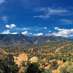 Slightly cloudy skies above mountains and fields