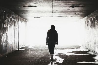 Rear view of man standing in tunnel