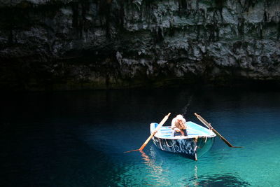 Man sitting in moored boat on lake