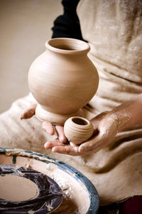 Sculpt man potter holds palms just made pitchers of different sizes. potter holds made pots. 