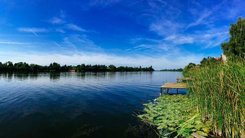 Scenic view of calm lake against cloudy sky