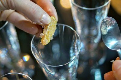 Close-up of hand holding lemon slice