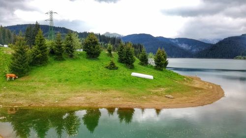 Scenic view of lake and mountains against sky