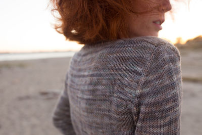 Rear view of woman at beach during sunset