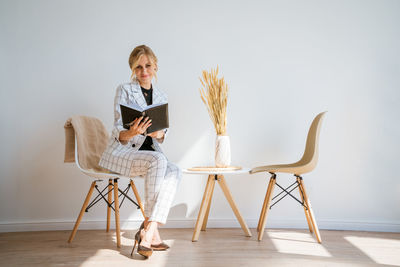 Pensive woman in office planning work schedule in notebook. sitting