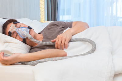 Man with oxygen mask sleeping on bed at hospital