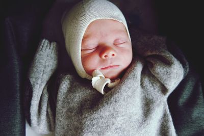 Close-up of cute baby boy sleeping on bed