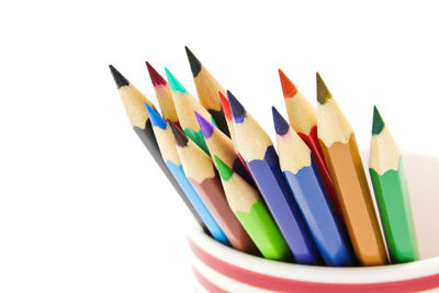 High angle view of colored pencils against white background
