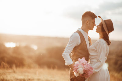 Rear view of couple holding bouquet