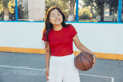 Portrait of young woman standing in court