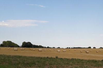 Hay bales on field against sky