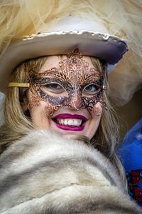 Close-up portrait of smiling woman in costume and mask during event