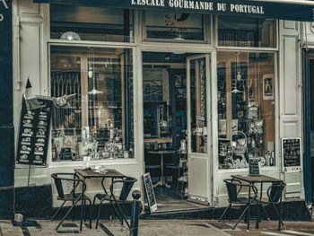 Empty chairs and tables in cafe against building