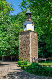 View of cross against trees and building