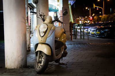 Motor scooter on sidewalk at night