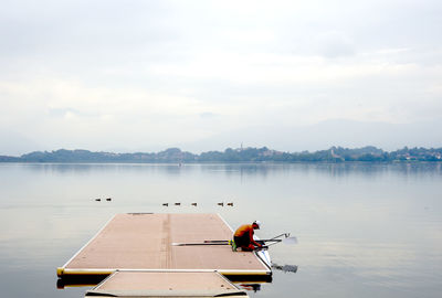 Men on boat in lake against sky
