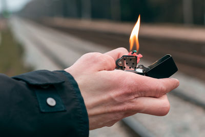 Close-up of hand holding lit candle