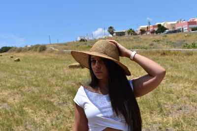 Woman wearing hat standing on field