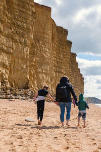 Rear view of people walking on rock