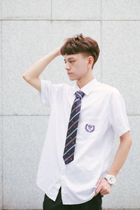 Mid adult man standing against white wall