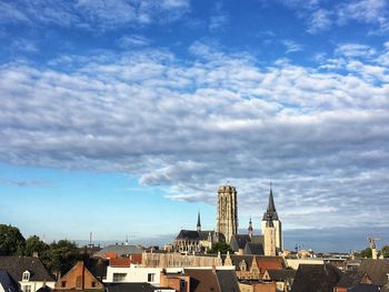 Buildings in city against cloudy sky