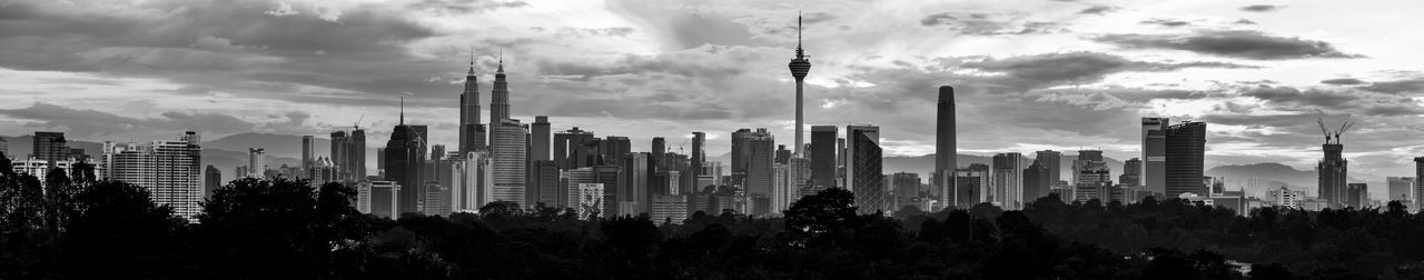 Panoramic view of buildings against cloudy sky