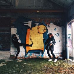 Full length of woman standing in graffiti