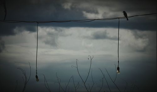 High section of electricity pylon against cloudy sky