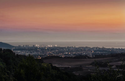 Aerial view of cityscape against sky at sunset