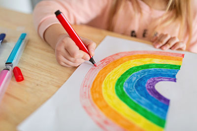 Kid painting rainbow during covid-19 quarantine at home. stay at home social media campaign 