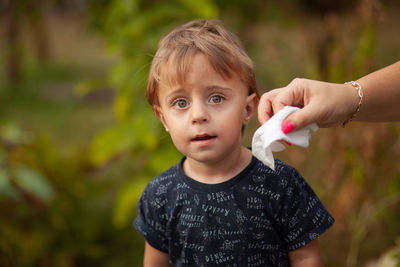 Portrait of cute boy holding outdoors
