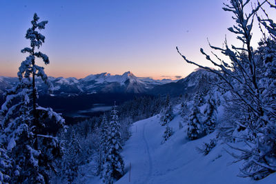 Scenic view of snow covered mountains against sky at sunset