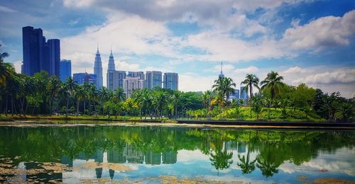 Scenic view of lake by buildings against sky