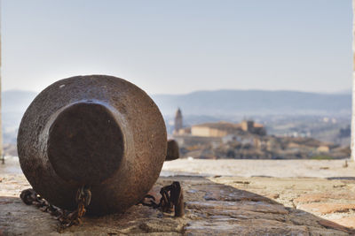 Close-up of old bell clapper in land against sky