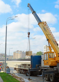 Cranes at construction site against sky