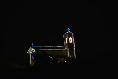 Illuminated building against clear sky at night