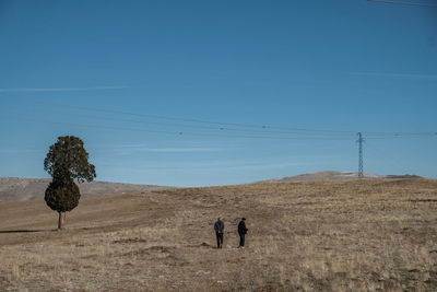 People walking on beach against sky