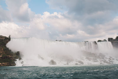 Scenic view of waterfall against sky