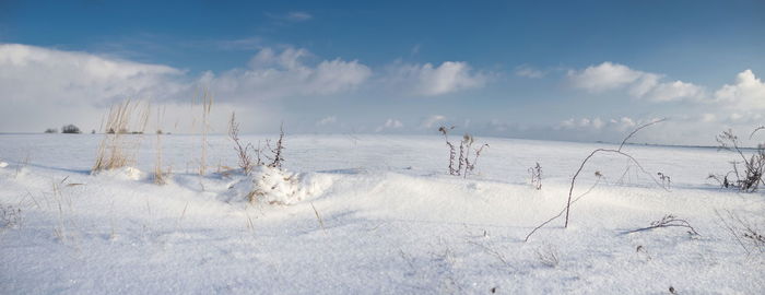 Panoramic view of snow covered field against sky