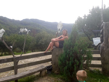 Panoramic view of shirtless man sitting on plants against sky