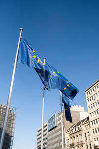 Low angle view of flags on building against sky