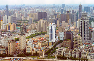 Aerial view of buildings in city against sky