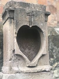 Close-up of heart shape hole on brick wall