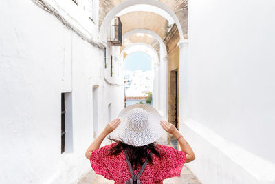 Rear view of woman standing against building