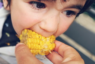 Cropped hand feeding sweetcorn to child